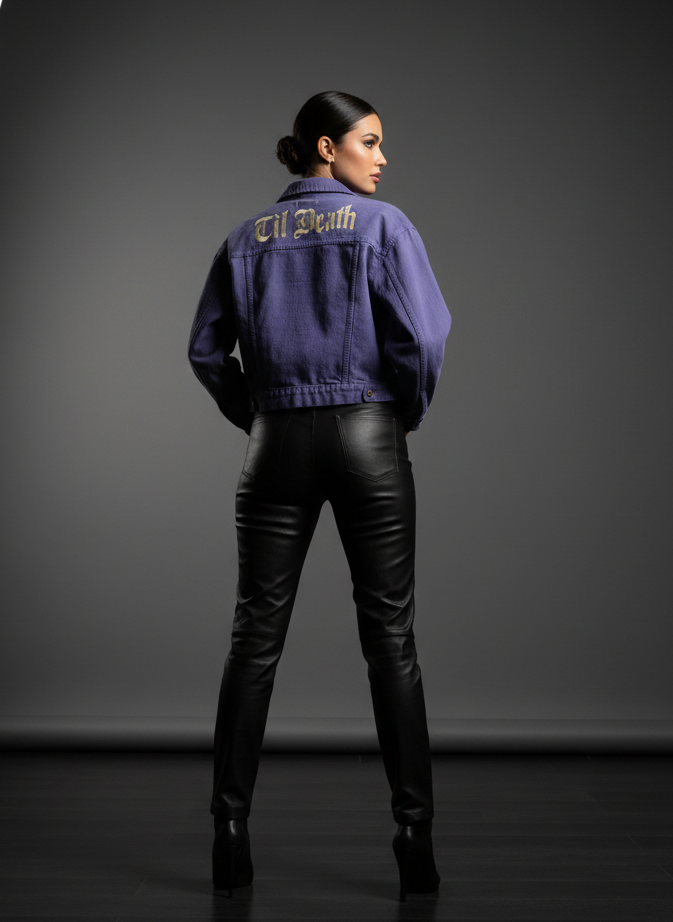 Person wearing a purple jacket with text on the back, standing against a dark background